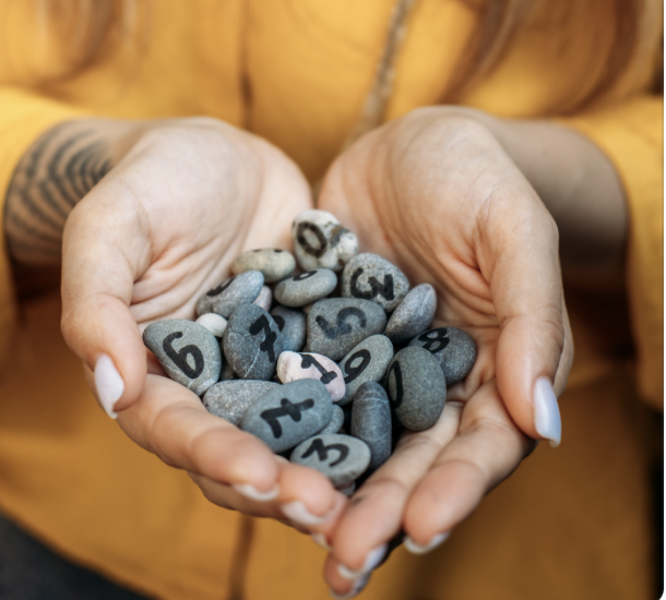 Numéros Des mains tenant des cailloux numérotés de 1 à 9, avec des teintes variées.